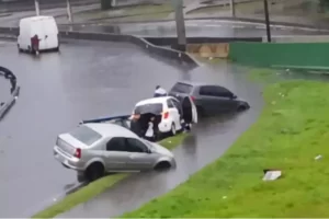 Veículos ficam presos em vala alagada após temporal em Cubatão