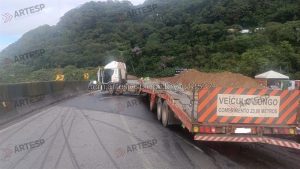 Carreta bate em mureta, fica em ‘L’ e trava a Anchieta