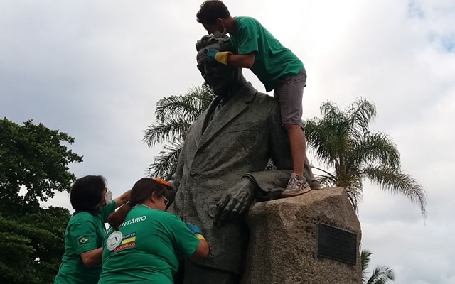 Voluntários limpam placas de bronze do Monte Serrat